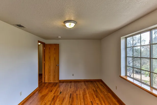 a view of a kitchen with wooden floor a ceiling fan and windows