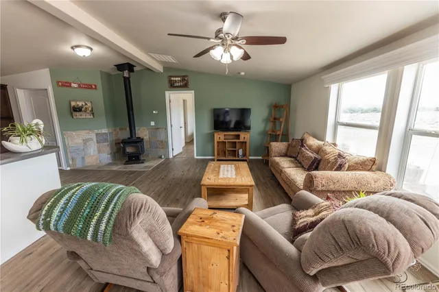 a living room with furniture fireplace and a large window
