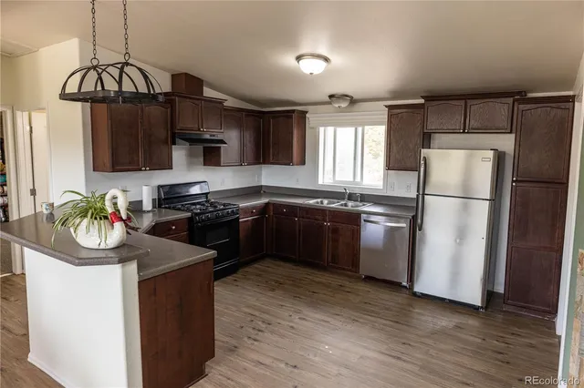 a kitchen with a sink a refrigerator a stove a microwave and cabinets