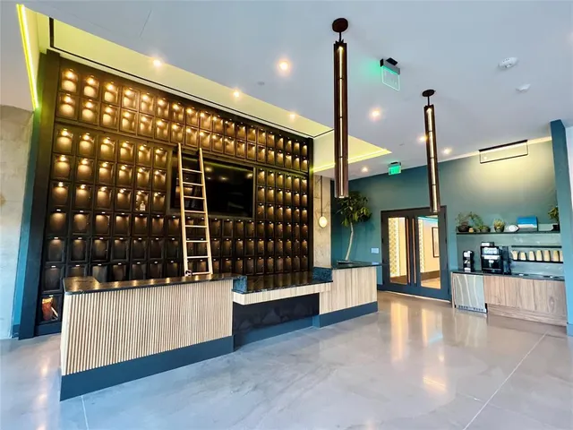 a view of lobby with a floor to ceiling window and potted plants