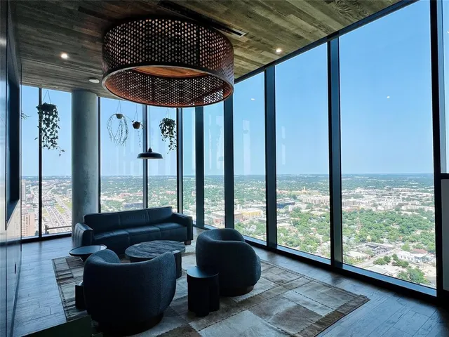 a living room with furniture and a floor to ceiling window