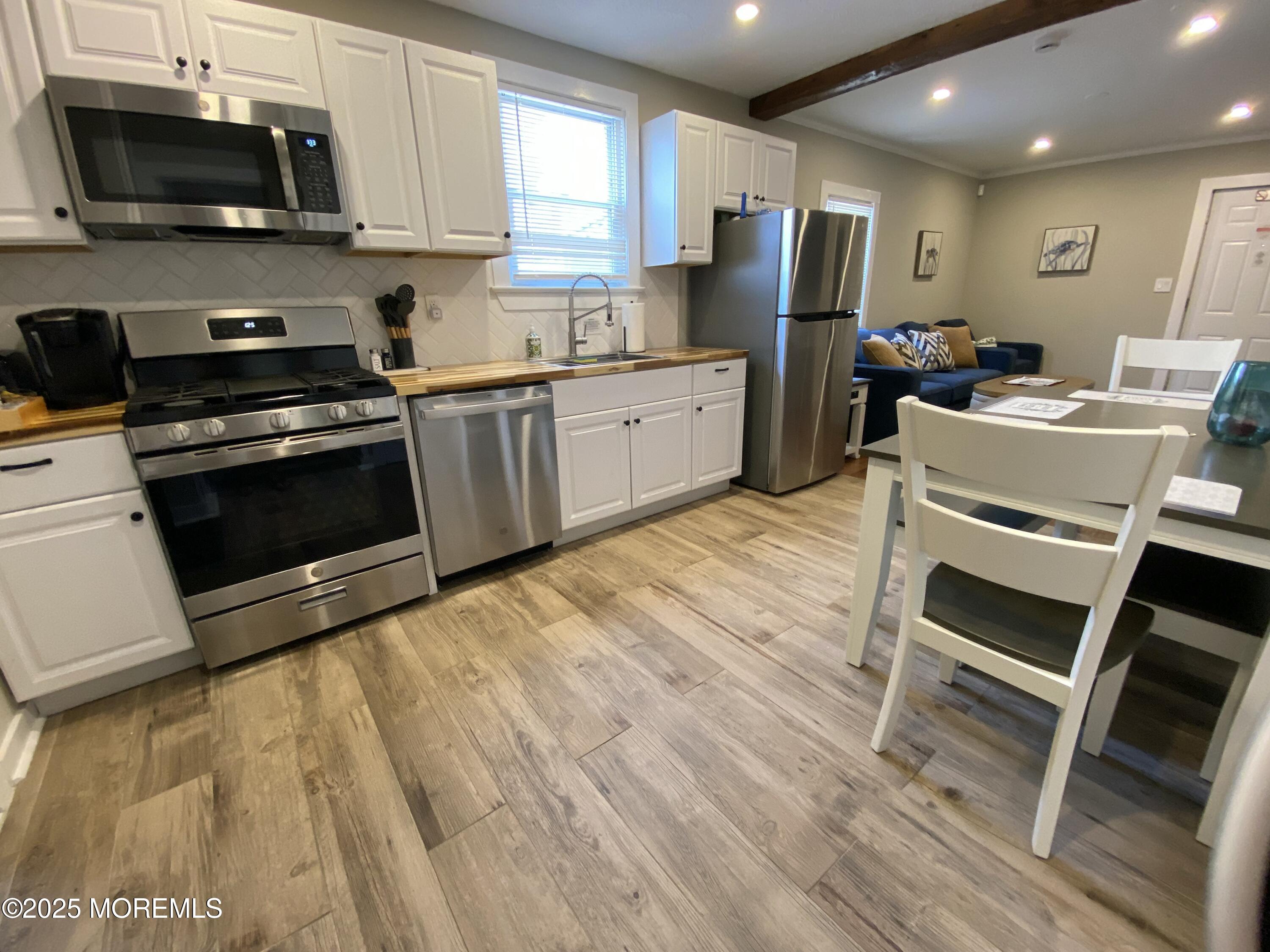215 Webster Avenue, Unit 1 Seaside Heights, NJ 08751 - Photo 4 of 14 a kitchen with stainless steel appliances a stove refrigerator sink and microwave