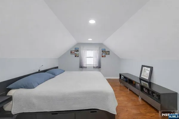 a bedroom with a bed and wooden floor