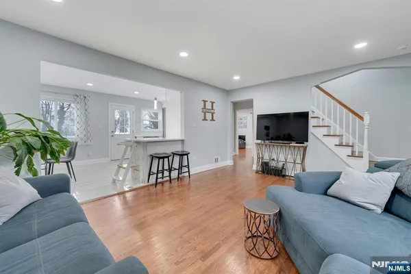 a living room with furniture and a flat screen tv with wooden floor