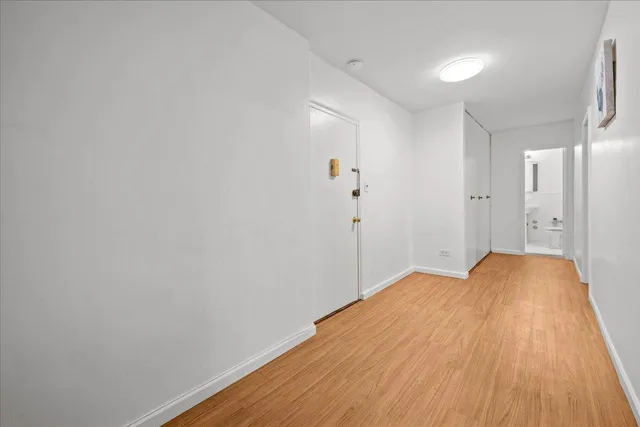 a view of empty room with wooden floor