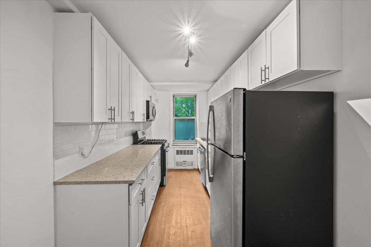 629 Kappock Street, Unit 1N Bronx, NY 10463 - Photo 6 of 12 a kitchen with a refrigerator a sink and cabinets