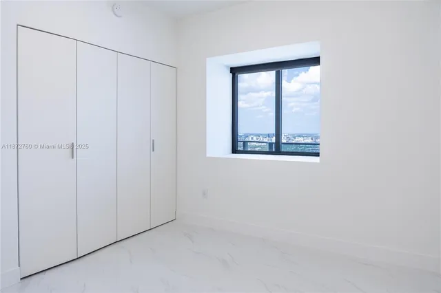 a view of an empty room with wooden floor and iron fence