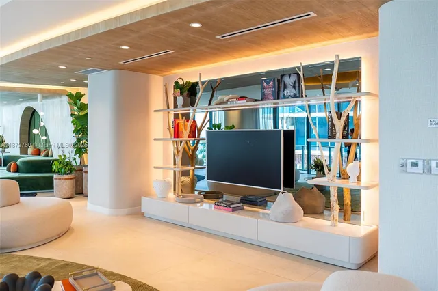 a living room with patio furniture and a potted plant