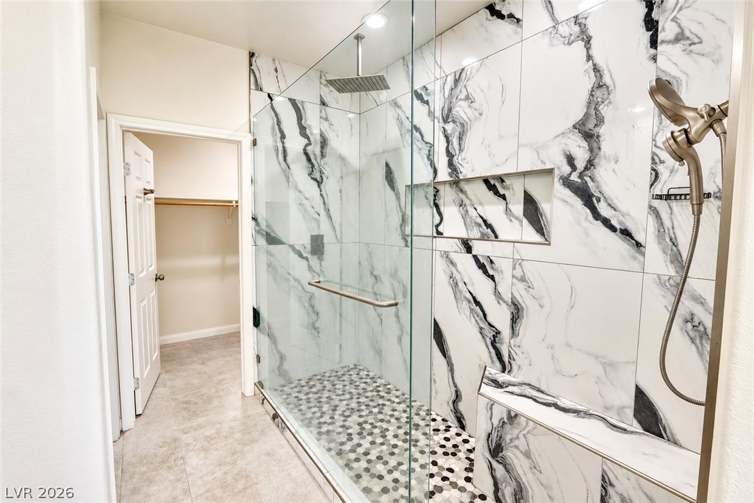 3104 Maple Ridge Court Henderson, NV 89052 - Photo 22 of 25 A glass-enclosed shower showcases marble-patterned tile walls paired with custom built-in features.