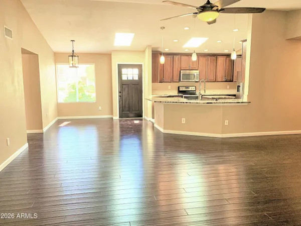 a view of a kitchen with kitchen island wooden floors wooden floor and stainless steel appliances