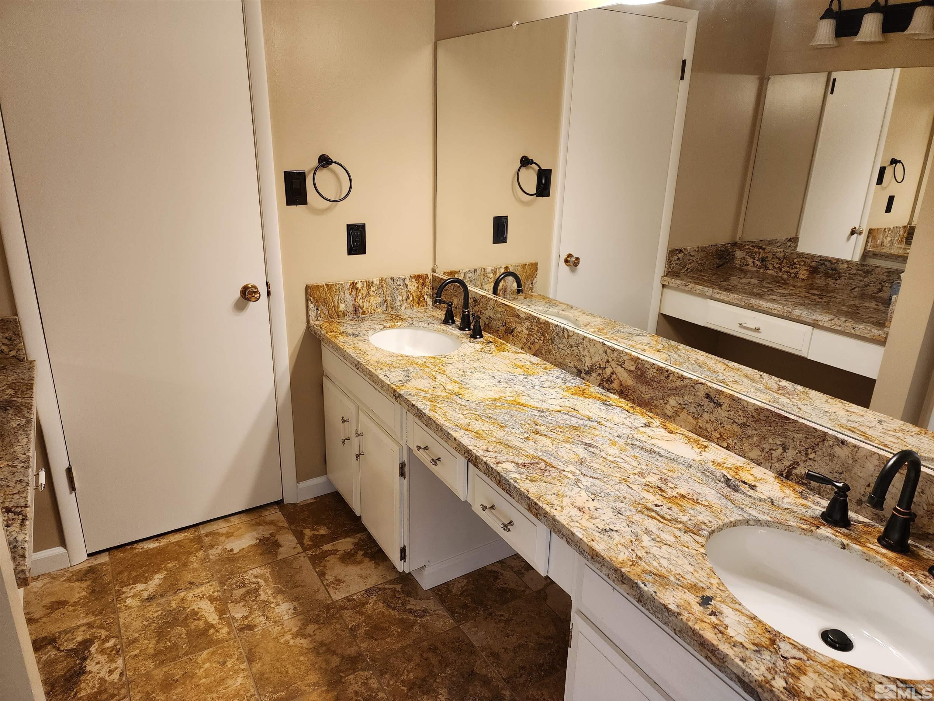 2945 Knight Road Reno, NV 89509 - Photo 5 of 11 a bathroom with a granite countertop sink and a mirror