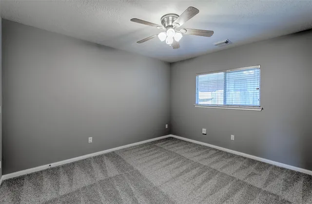 a view of an empty room with a chandelier fan