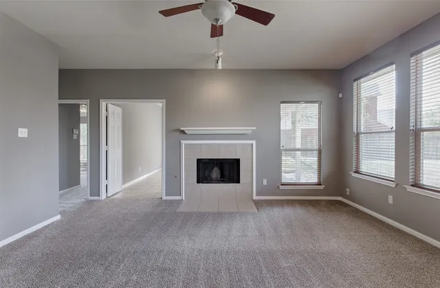 wooden floor fireplace and windows in an empty room