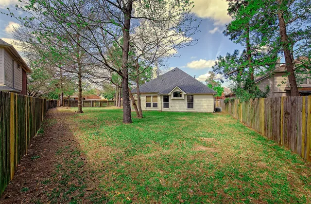 a front view of a house with yard and tree