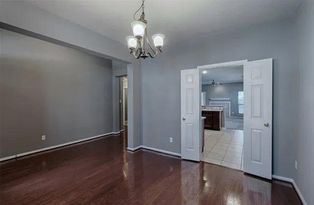 a view of a hallway with wooden floor and a chandelier