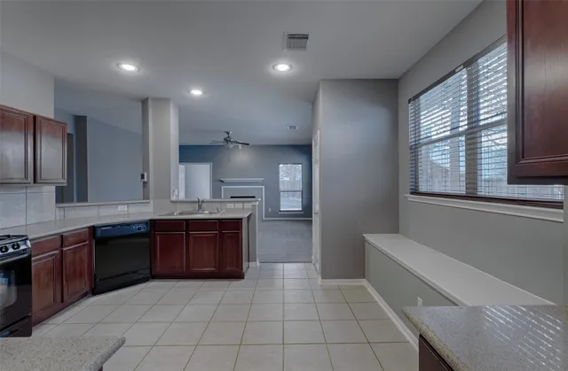 a large kitchen with stainless steel appliances granite countertop a stove and a sink