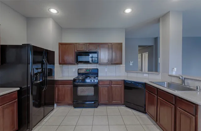 a kitchen with stainless steel appliances granite countertop a refrigerator and a sink
