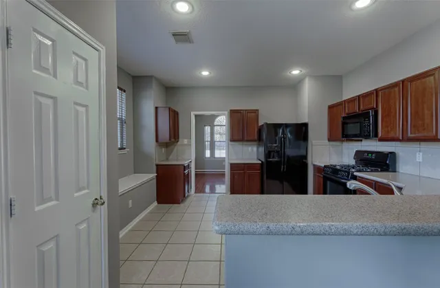 a kitchen with stainless steel appliances granite countertop a refrigerator and a sink