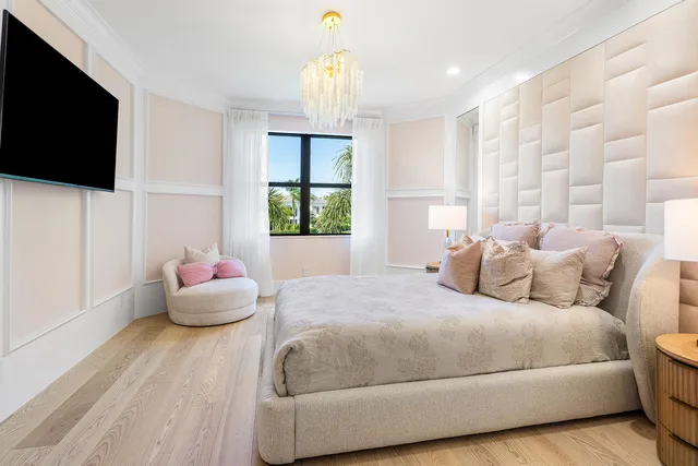 a bedroom with a large bed and a chandelier