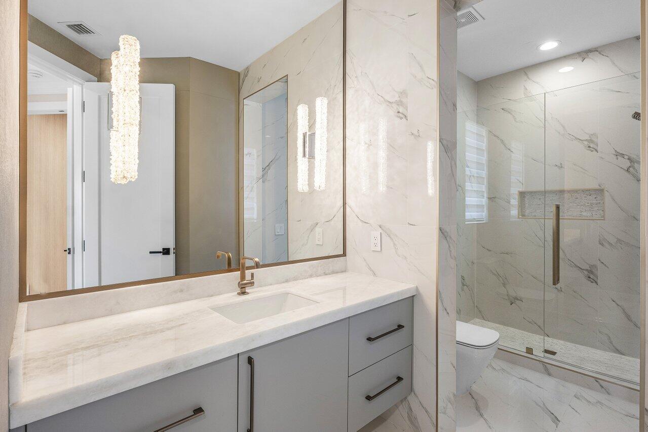 17709 Circle Pond Court Boca Raton, FL 33496 - Photo 29 of 50 a bathroom with a granite countertop sink a toilet and shower