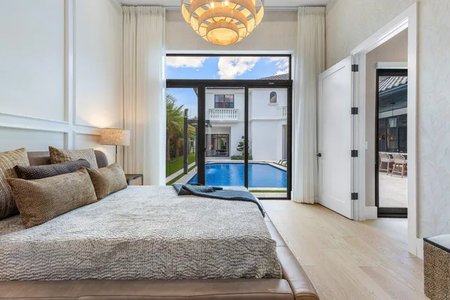 a spacious bedroom with a large bed and a chandelier