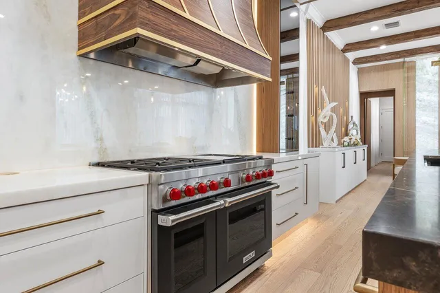 a kitchen with a stove and a wooden floor