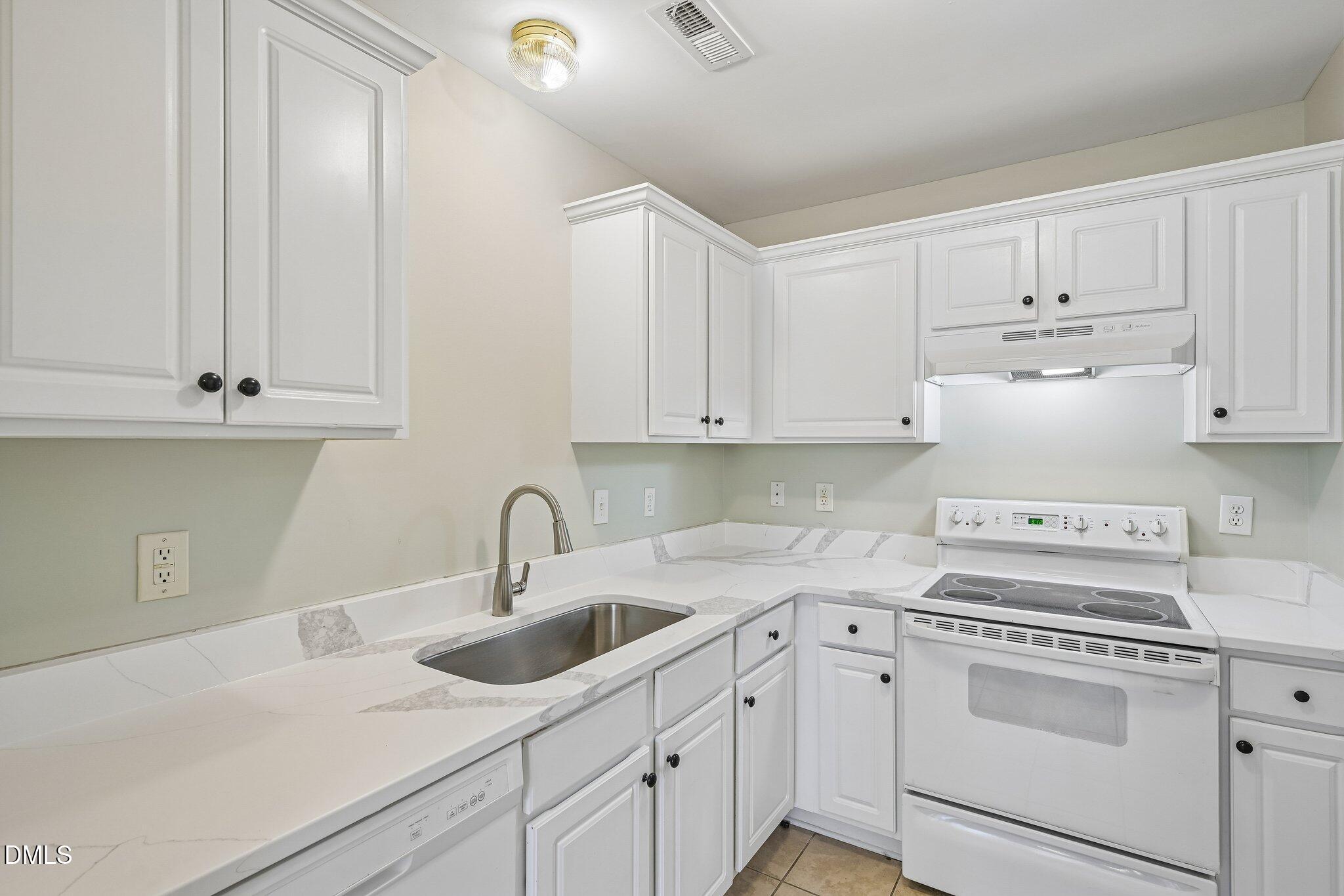278 South Raleigh Street Angier, NC 27501 - Photo 2 of 35 a kitchen with white cabinets sink and stove