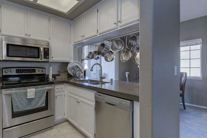 108 Arbor Way Milpitas, CA 95035 - Photo 17 of 26 a kitchen with white cabinets and black appliances