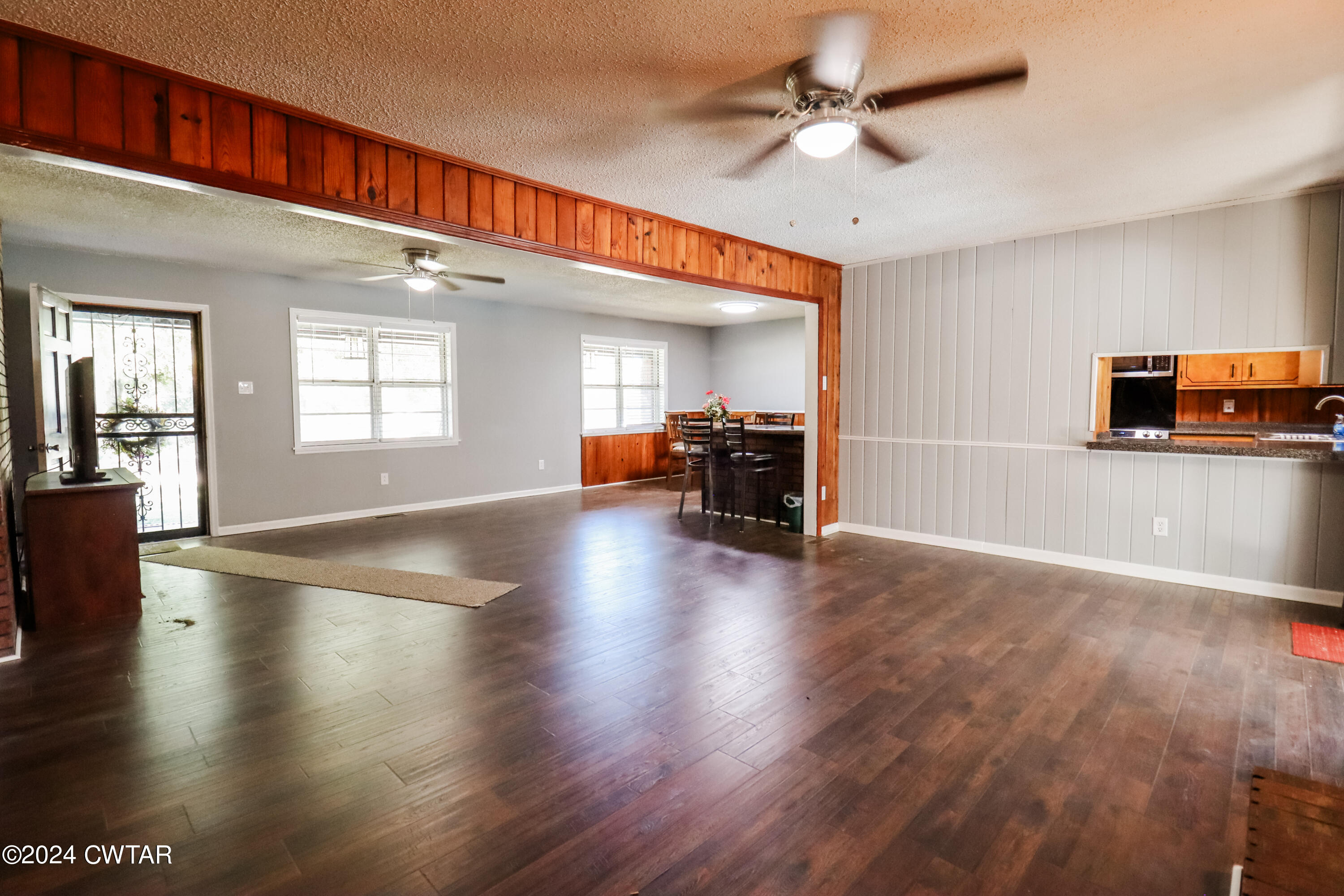 2046 Barlow Road Ripley, TN 38063 - Photo 6 of 28 a view of a livingroom with furniture hardwood floor a ceiling fan and windows