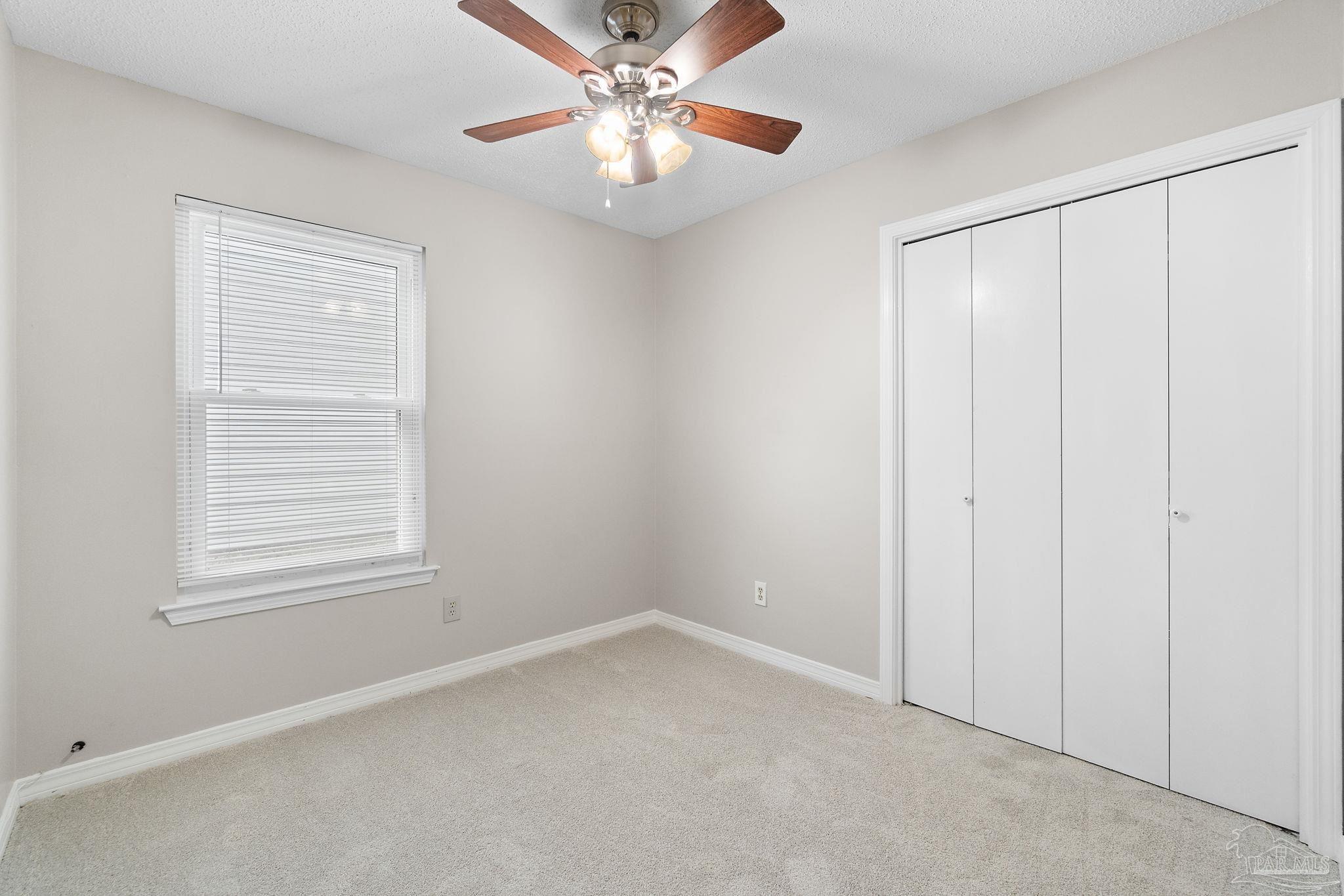 3440 Riverside Drive Pensacola, FL 32514 - Photo 16 of 26 an empty room with windows and fan