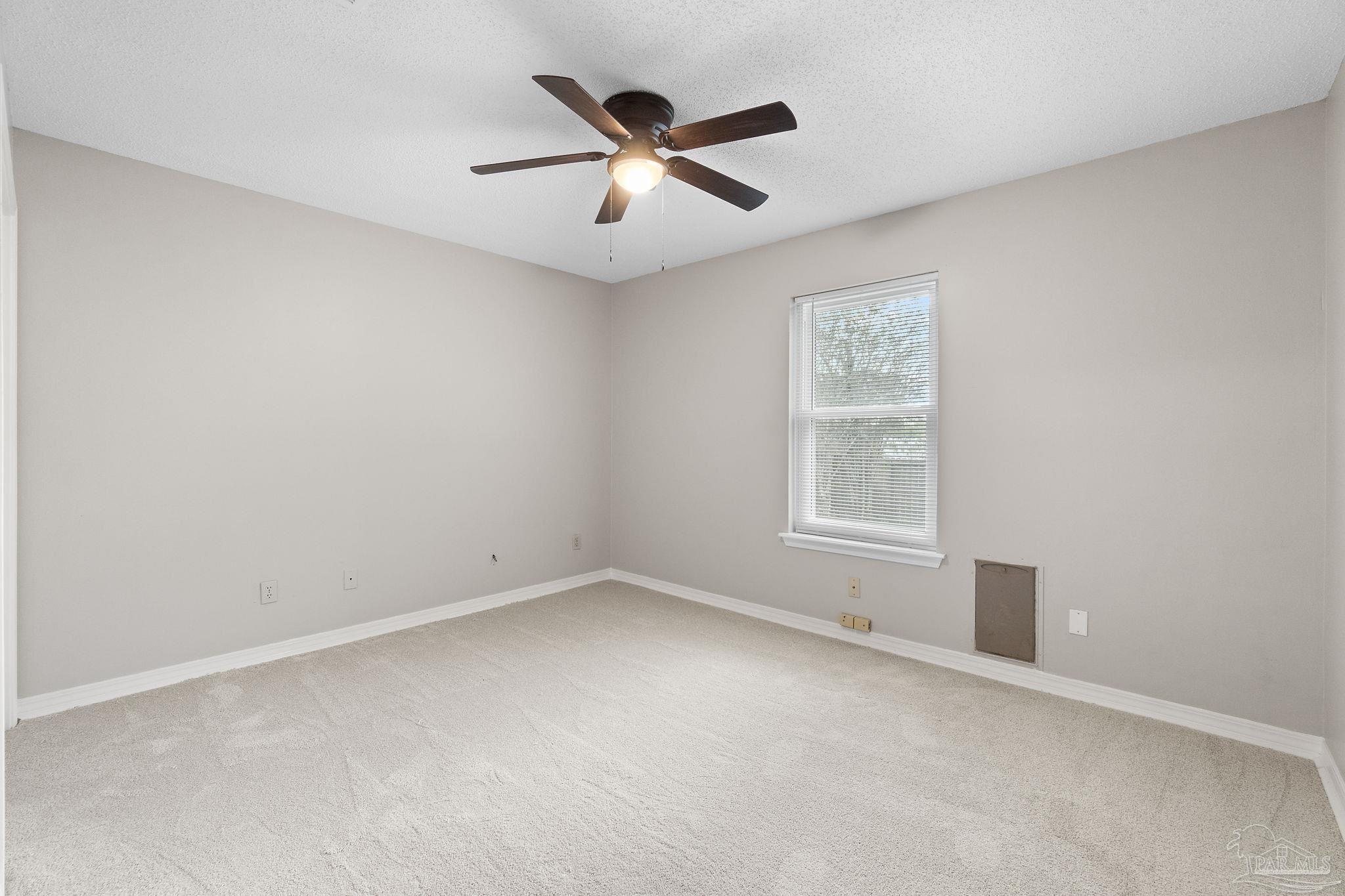 3440 Riverside Drive Pensacola, FL 32514 - Photo 19 of 26 an empty room with ceiling fan and windows