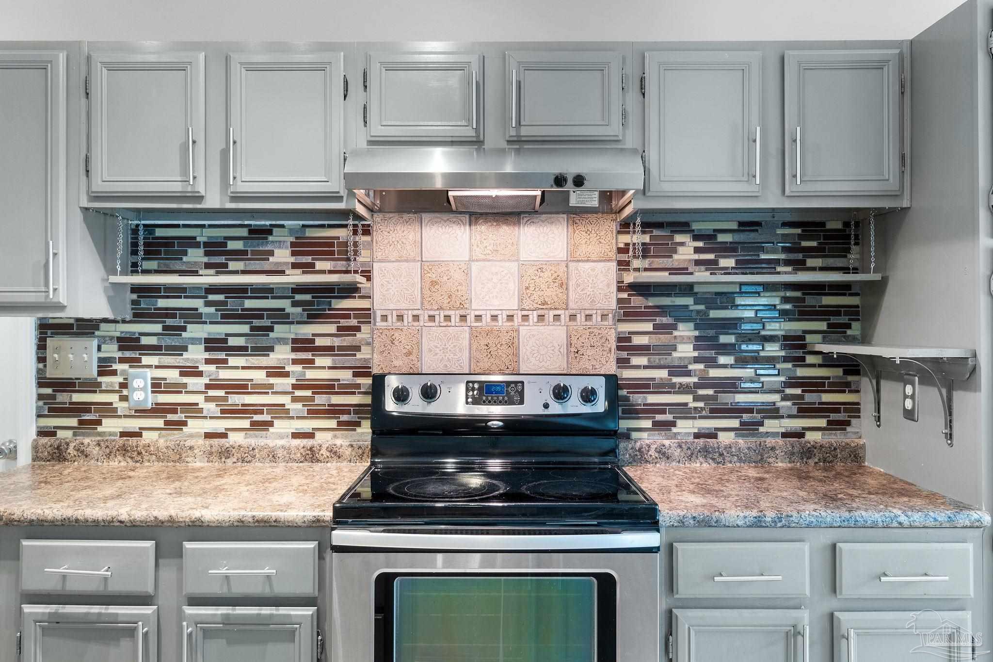 3440 Riverside Drive Pensacola, FL 32514 - Photo 10 of 26 a kitchen with granite countertop a stove and cabinets