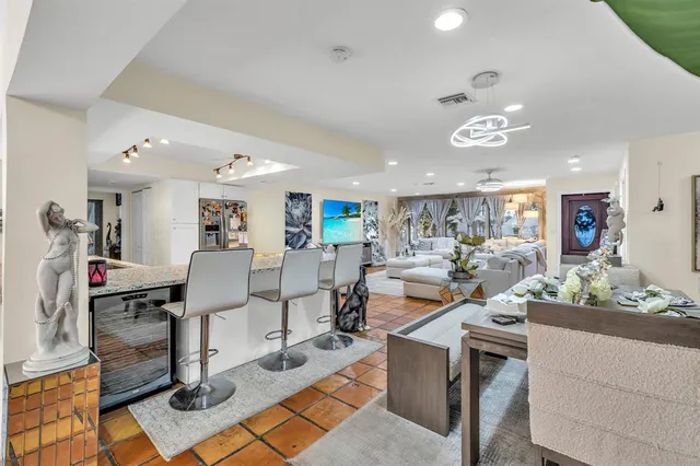 a living room with lots of furniture and view of kitchen