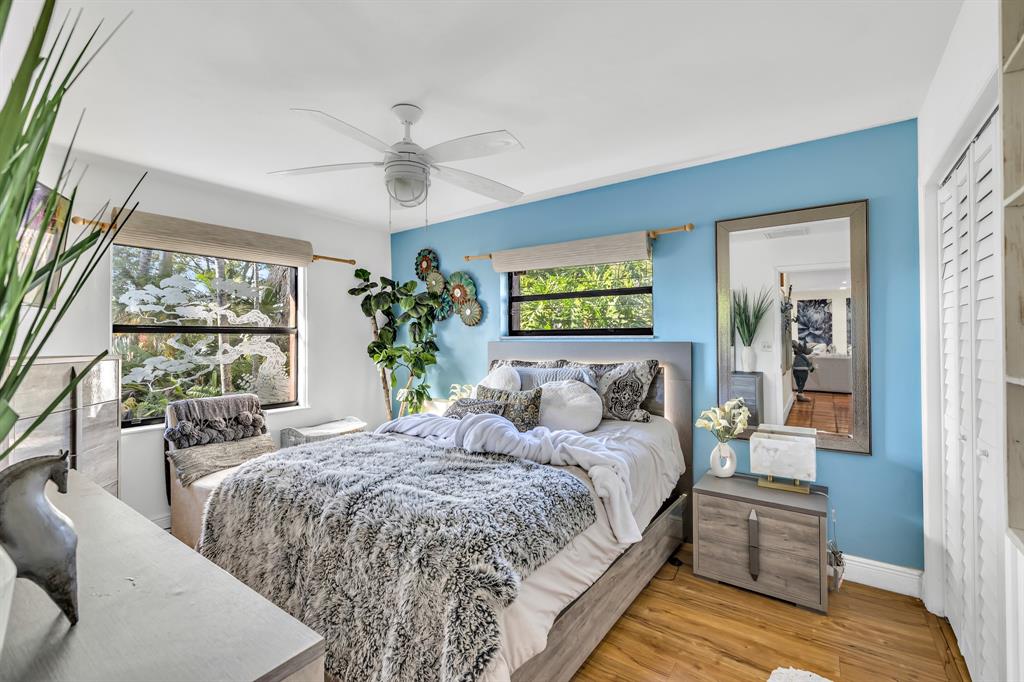 980 Southwest 70th Avenue Plantation, FL 33317 - Photo 24 of 42 a bedroom with a large bed and a chandelier