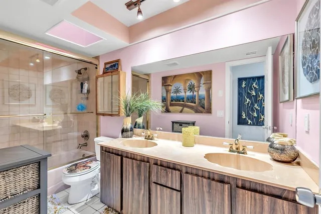 a bathroom with a double vanity sink toilet and a mirror