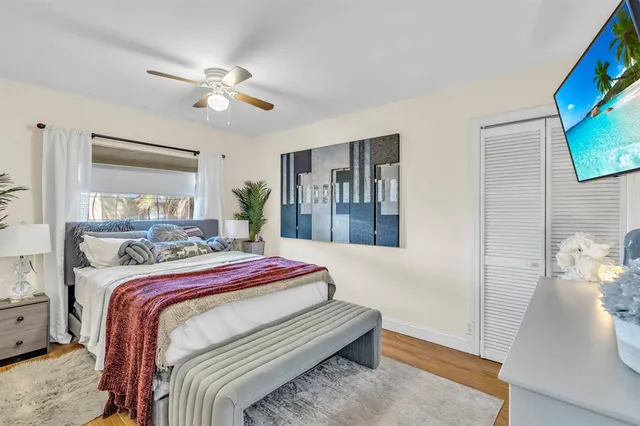 a bedroom with a bed a mirror on dresser and a chandelier
