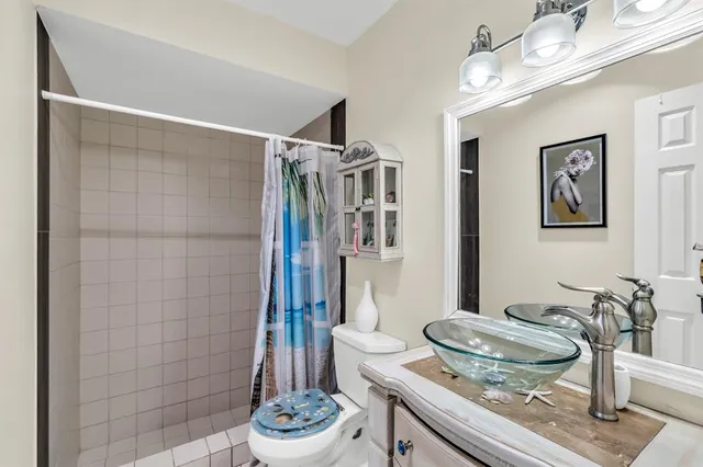 a bathroom with a granite countertop sink a toilet and a shower