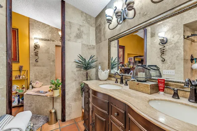 a bathroom with a granite countertop sink a large mirror and a shower