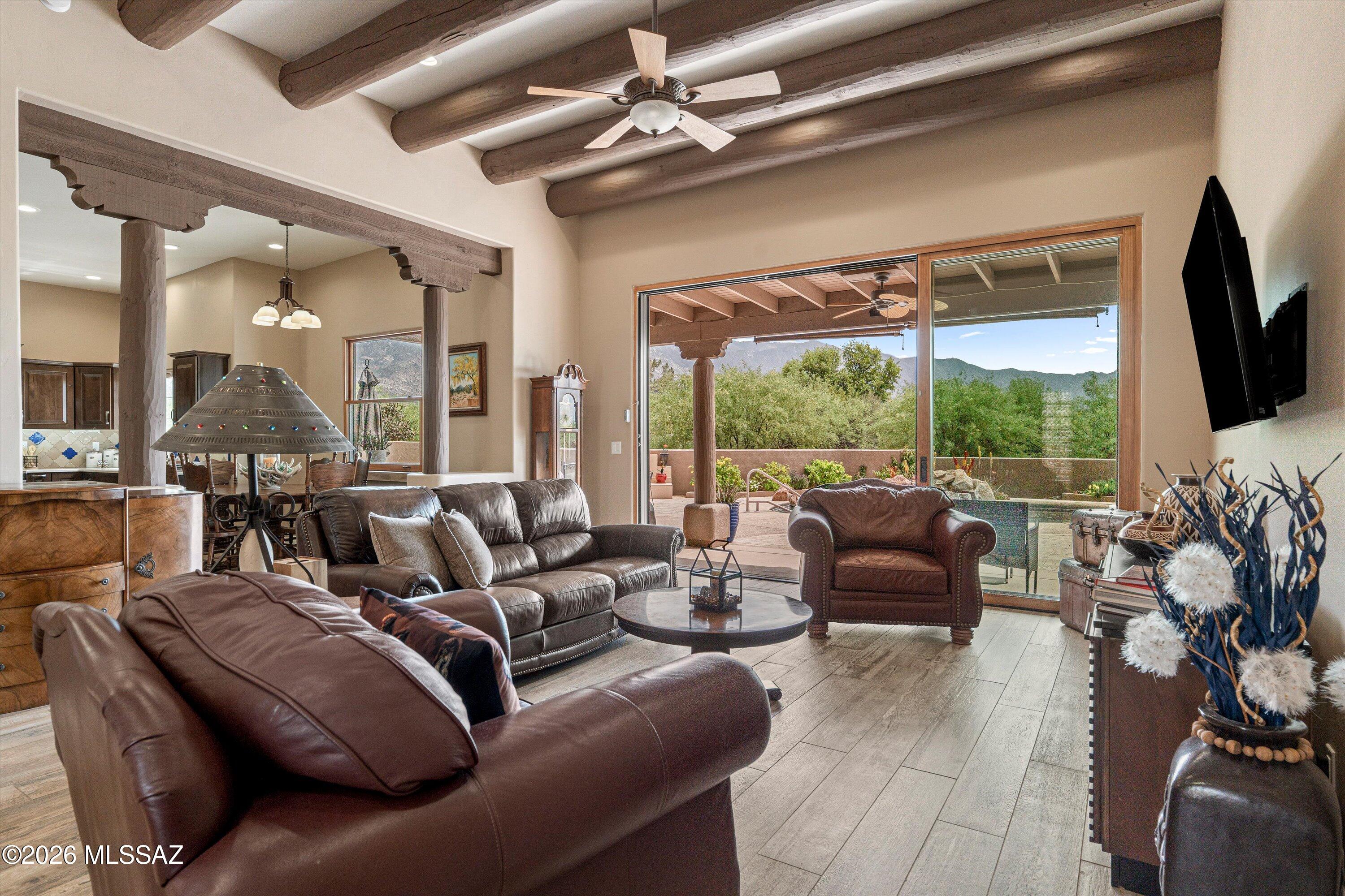 4760 East Wagon Train Road Tucson, AZ 85739 - Photo 7 of 38 a living room with furniture a flat screen tv and a large window