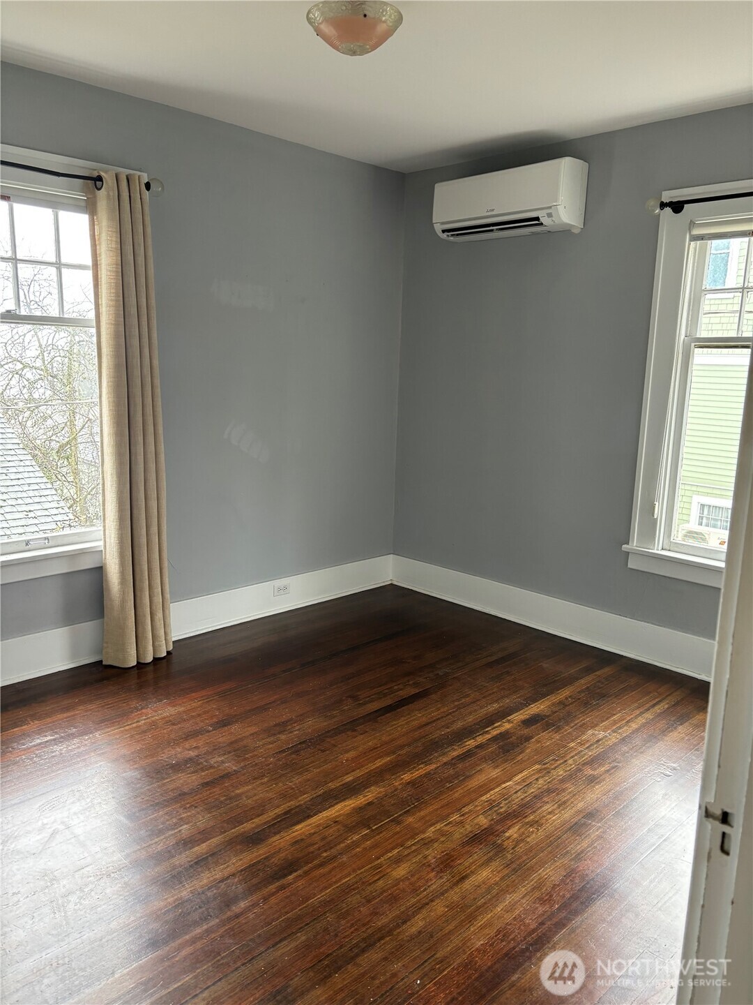 3201 South Charles Street Seattle, WA 98144 - Photo 7 of 23 an empty room with wooden floor and windows