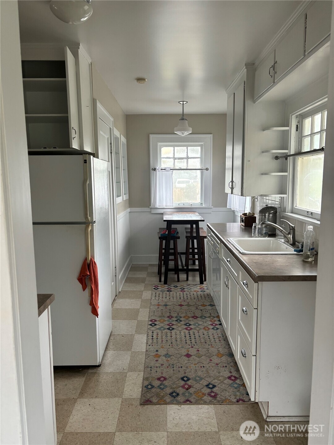 3201 South Charles Street Seattle, WA 98144 - Photo 8 of 23 a kitchen with stainless steel appliances granite countertop a refrigerator a sink dishwasher a dining table and chairs with wooden floor