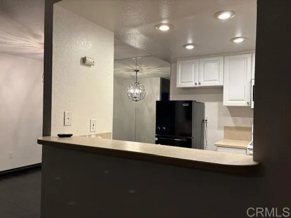 a view of kitchen with refrigerator and window