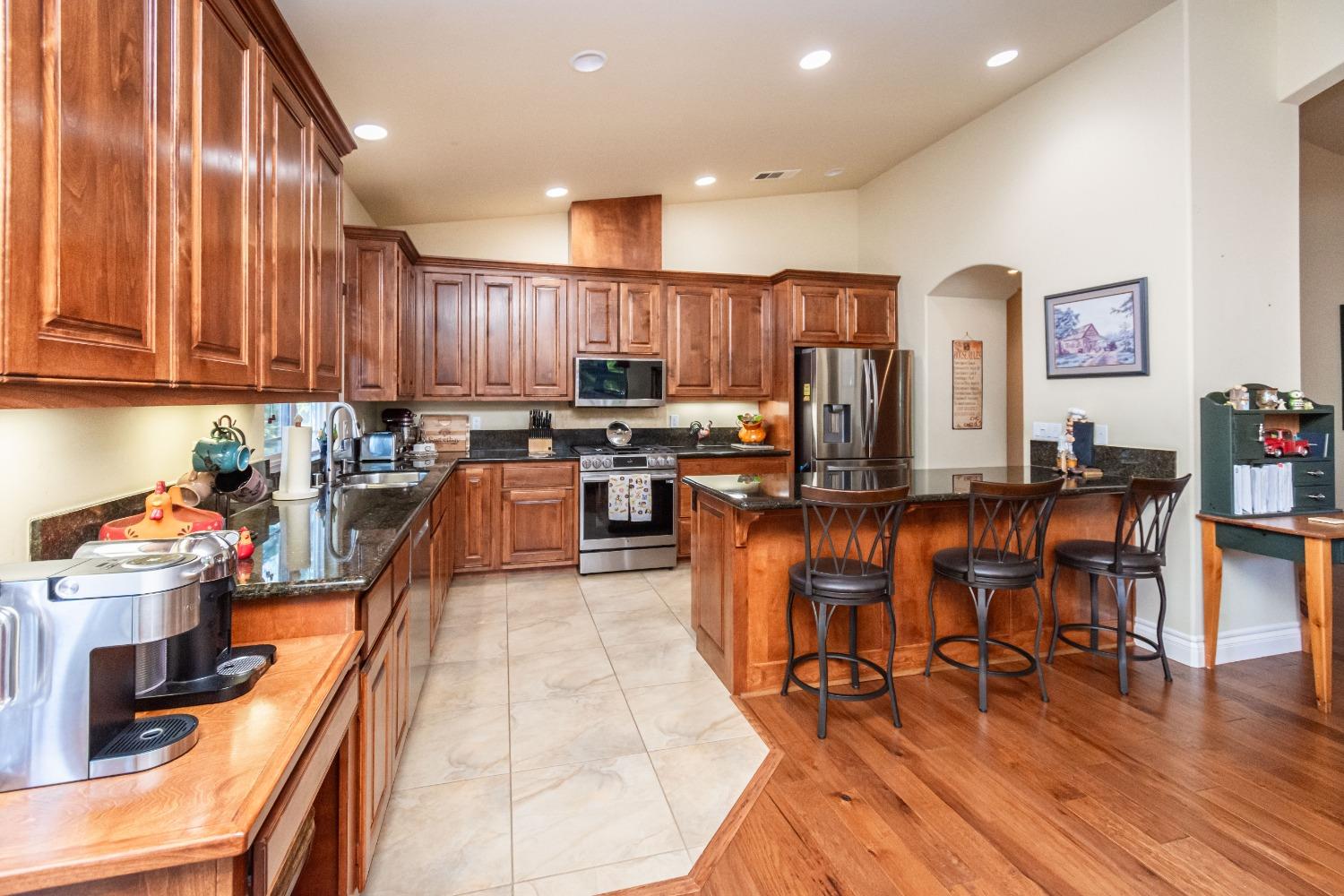 6570 Mosquito Road Placerville, CA 95667 - Photo 22 of 56 a kitchen with stainless steel appliances wooden floors stove top oven and cabinets