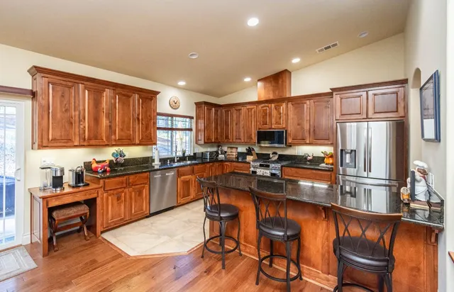 a kitchen with stainless steel appliances granite countertop a stove and a sink