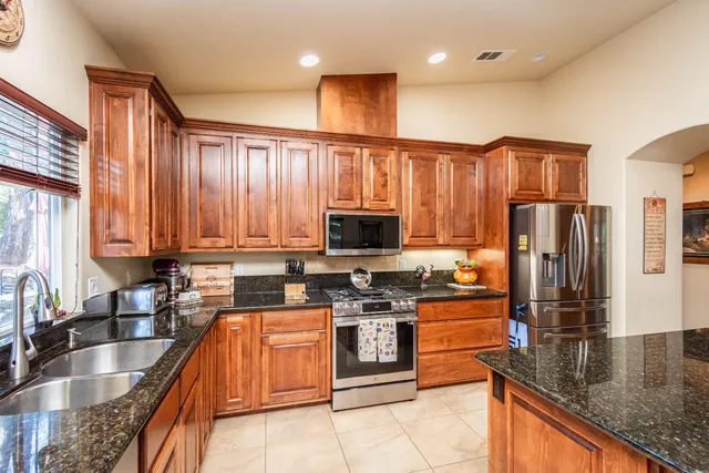 a kitchen with stainless steel appliances granite countertop a refrigerator and a sink