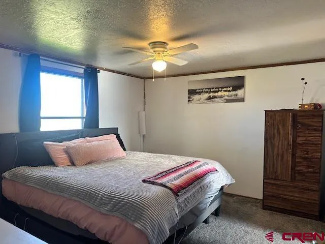 a bedroom with a bed and a dresser with wooden floor