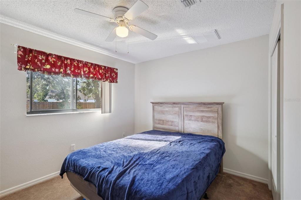 8340 Nevada Street Spring Hill, FL 34606 - Photo 14 of 23 a bedroom with a bed and a chandelier
