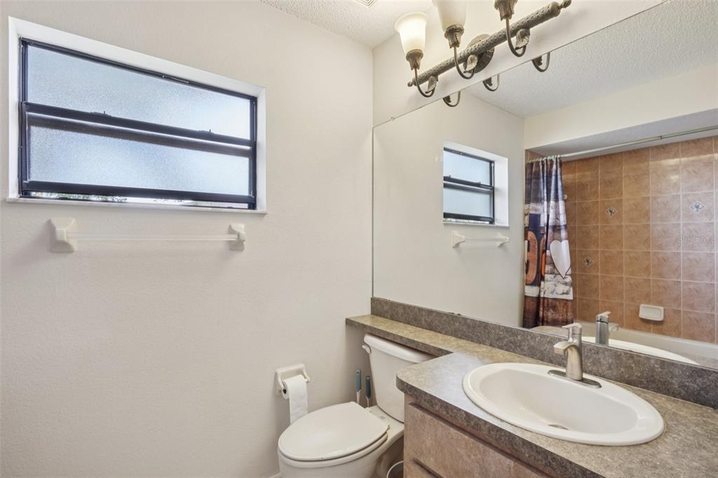 8340 Nevada Street Spring Hill, FL 34606 - Photo 16 of 23 a bathroom with a toilet a sink and mirror