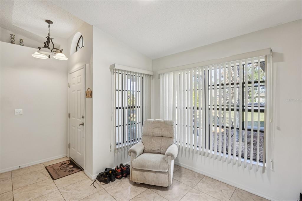8340 Nevada Street Spring Hill, FL 34606 - Photo 2 of 23 a living room with furniture and a chandelier