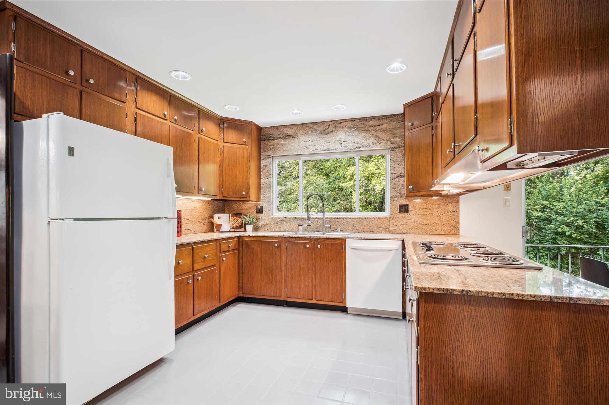 302 Ellsworth Drive Silver Spring, MD 20910 - Photo 43 of 64 a kitchen with granite countertop a refrigerator a sink a stove and white cabinets